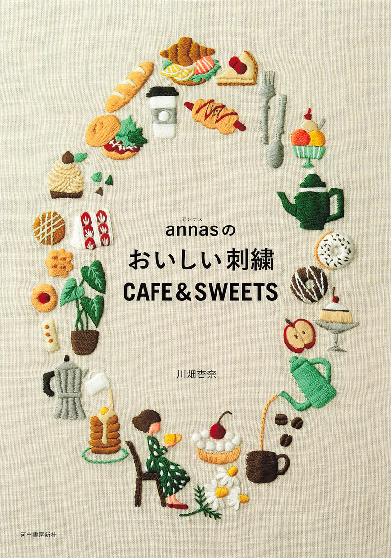 20221014_631 Cover of a Japanese cafe embroidery patterns book by annas, with a ring of stitched croissants, cakes, coffee and teapots