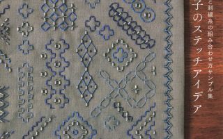 Cover of this Japanese beads sashiko embroidery book showing dense blue and silver geometric sashiko bead stitch patterns on grey linen fabric.