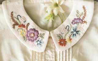 French embroidery pattern book cover featuring a white blouse with hand-stitched floral Peter Pan collar designs