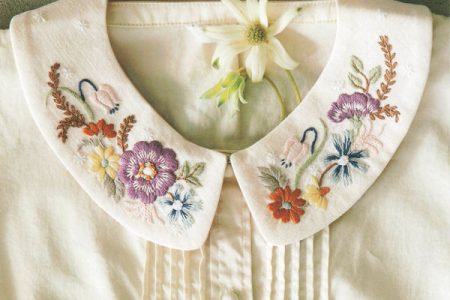 French embroidery pattern book cover featuring a white blouse with hand-stitched floral Peter Pan collar designs