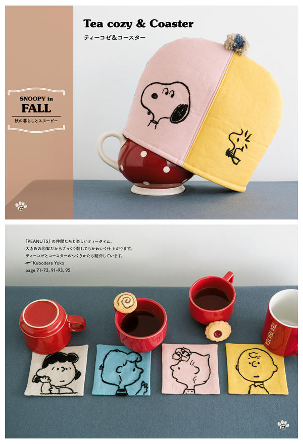 h Pink and yellow tea cozy embroidered with Snoopy and Woodstock faces, and a set of four Peanuts character coasters beside red mugs
