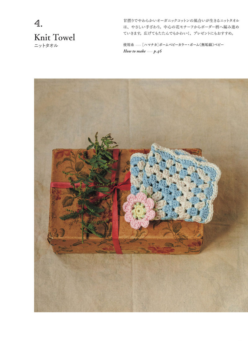 00011 Folded blue and cream crochet towel pattern in organic cotton, tied to a gift box with a pink flower