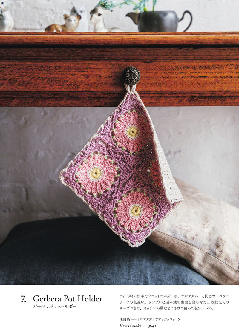 00015 Mauve and pink crochet pot holder pattern with gerbera motifs, hanging from a brass shelf knob