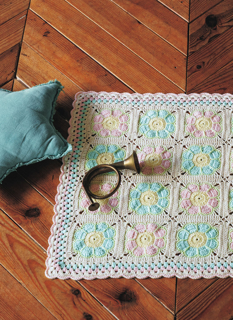 00024 Pastel crochet baby blanket pattern in mint, pink and lemon flower squares on a wooden floor