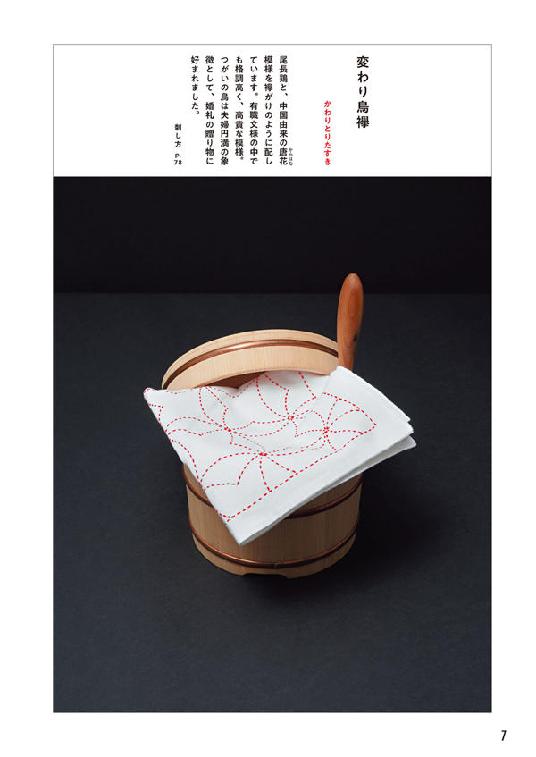 1284-index-9_1 Red thread sashiko embroidery in a bird motif, draped over a wooden rice tub.