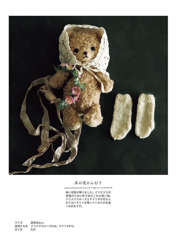 1466-00012 A teddy bear in a lace bonnet wears a winter flower crown worked from a crochet Christmas rose pattern.