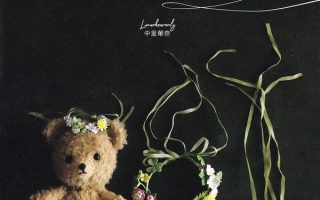Cover of this crochet flower patterns book, showing a teddy bear in a flower crown beside wreath brooches.