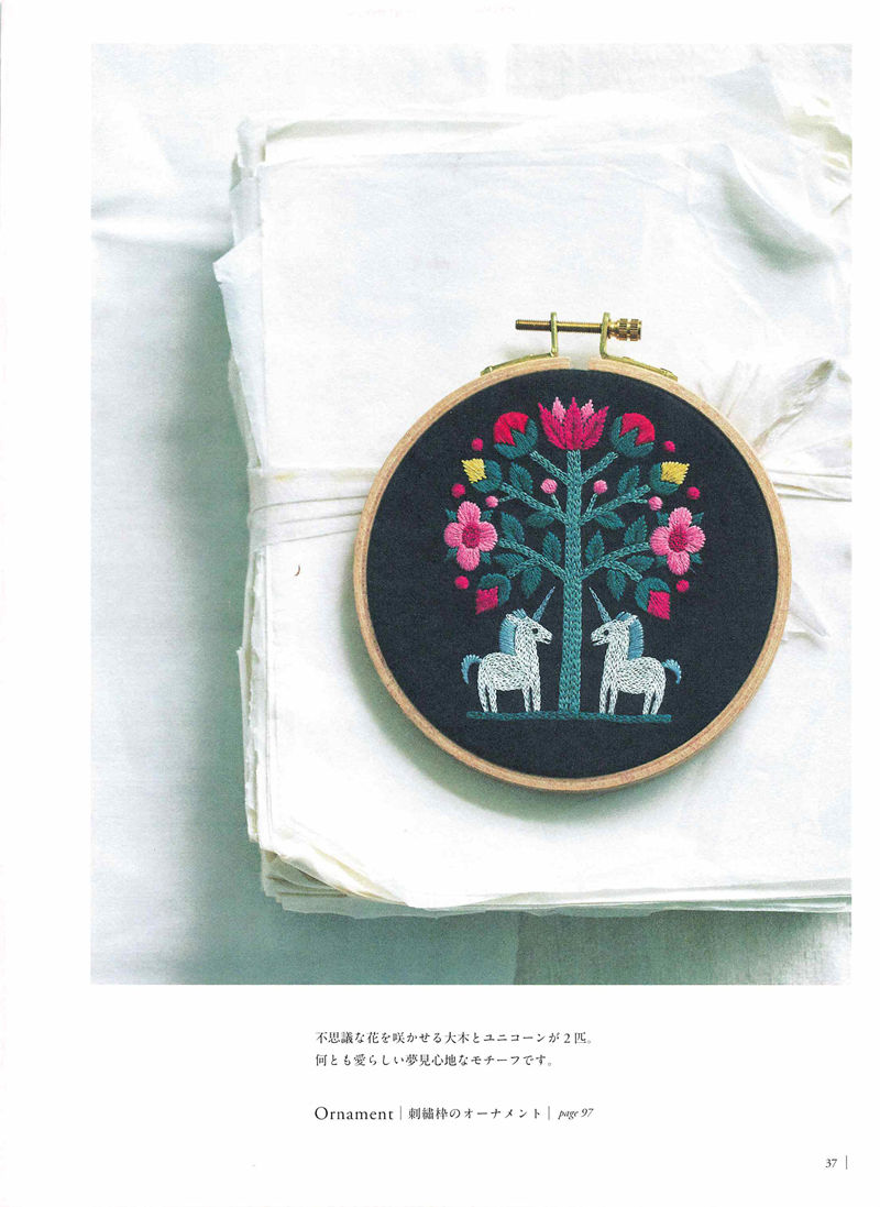 1505-09042026220514_039 Unicorn and tree hoop embroidery design by Yumiko Higuchi in pink and green, hung as an ornament.