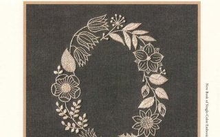 Cover of a Yumiko Higuchi embroidery single color embroidery patterns book — an oval wreath of flowers and leaves in cream on charcoal linen.