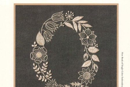 Cover of a Yumiko Higuchi embroidery single color embroidery patterns book — an oval wreath of flowers and leaves in cream on charcoal linen.