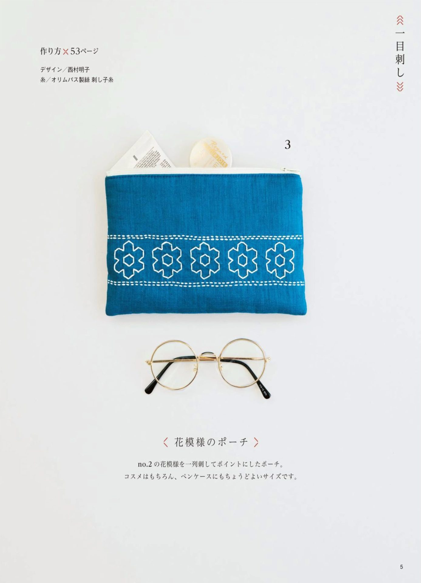 1283-p07 Blue sashiko zip pouch with a white flower motif band beside round glasses, a small pouch pattern