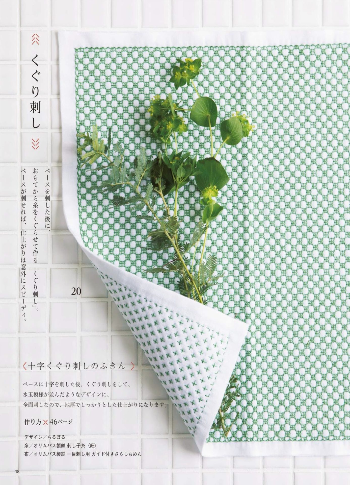1283-p20 Green kuguri sashiko cloth with a threaded cross pattern, lifted to show a leafy stem