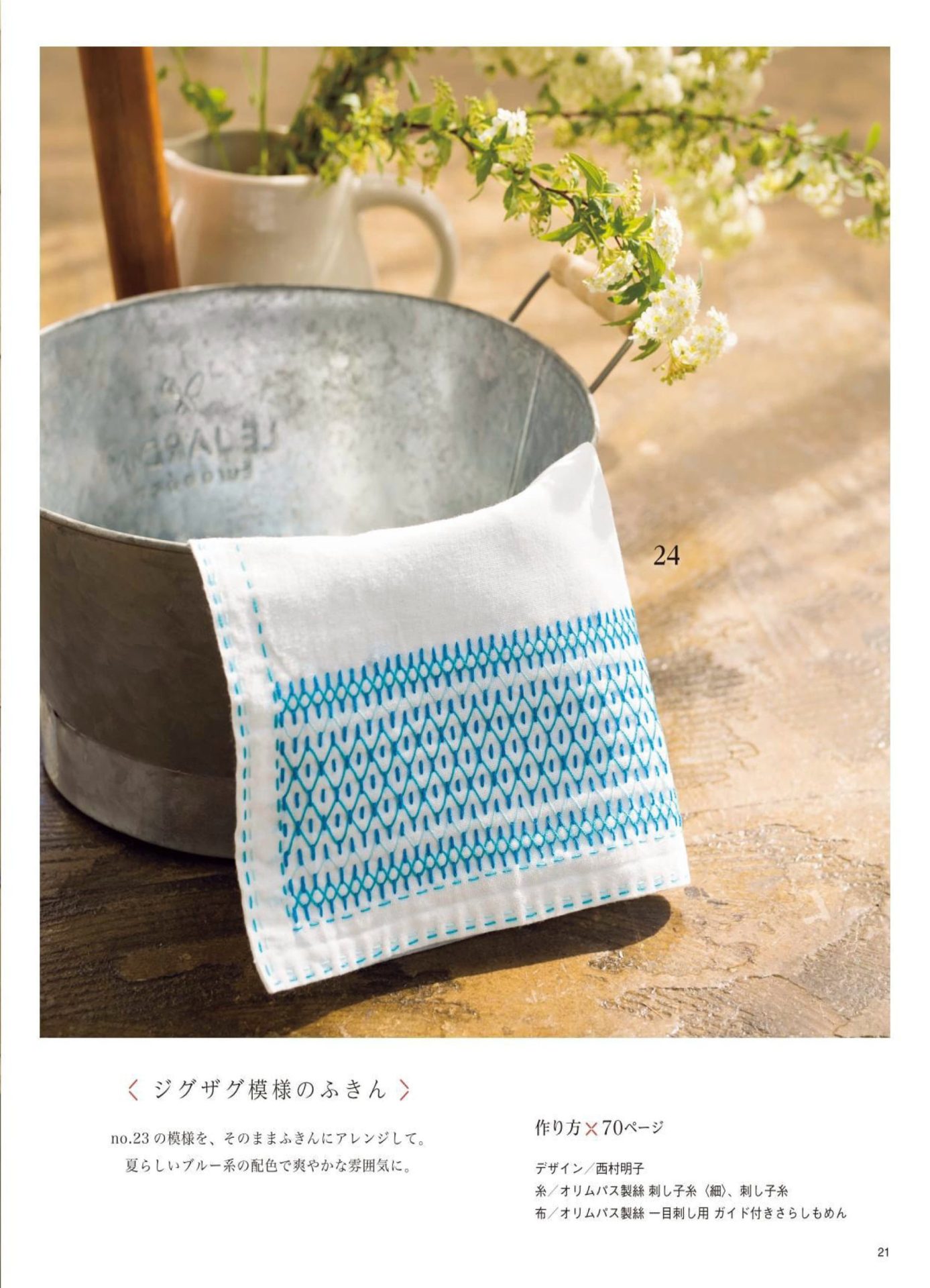 1283-p23 Sashiko dishcloth with a blue zigzag diamond band draped over a metal bucket of flowers