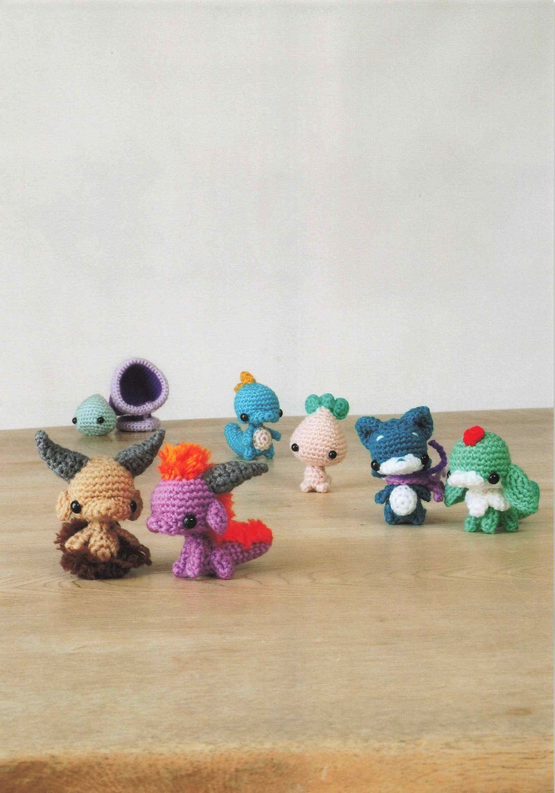 1495-04232026184535_008 Colorful tiny crochet monsters clustered together, a group of mini amigurumi creatures