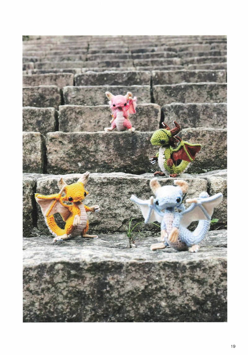 1495-04232026184535_022 Crochet dragons on gray stone steps, tiny amigurumi creatures with horns and wings