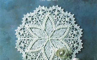 Cover of a book of crochet doily patterns A to Z, a white star doily with bobble stitches and roses on dusky blue