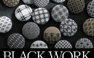 Blackwork embroidery patterns book cover with round fabric buttons stitched in black geometric designs